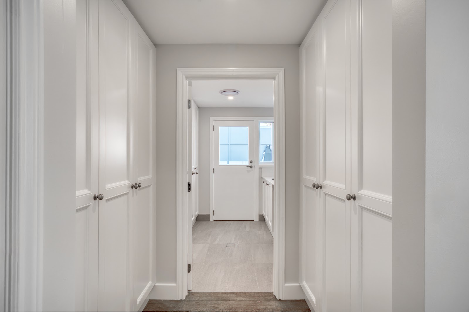 Hallway lined with white shaker built-in cupboards